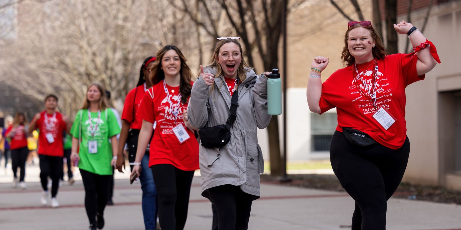 People smiling and cheering as they walk.